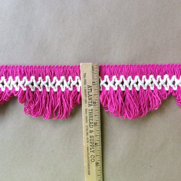 A measuring tape with a scalloped lace fringe trim.