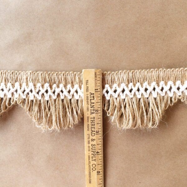 A measuring tape with Scalloped Lace Fringe tassels.