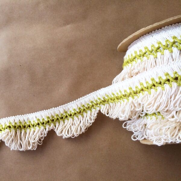 A spool of Scalloped Lace Fringe on a table.