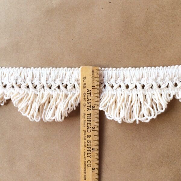 A measuring tape with Scalloped Lace Fringe trim.