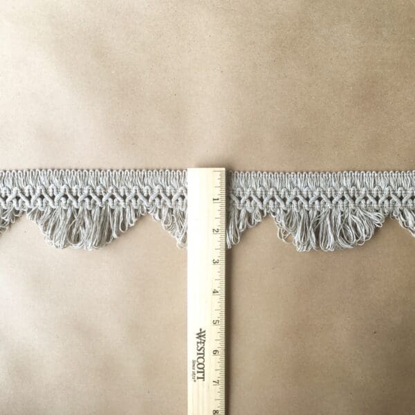 A 3IN Scalloped Lace Fringe Outdoor with a measuring tape on it.