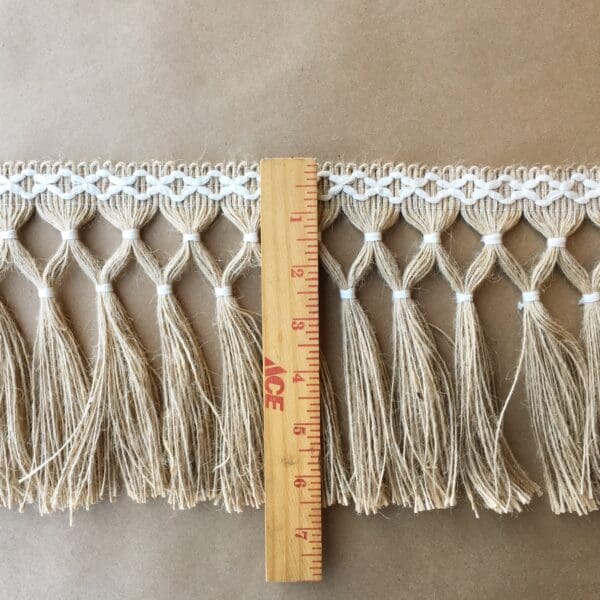 A Diamond Double Knot 6.5 - Jute with Natural Cotton with tassels on it.