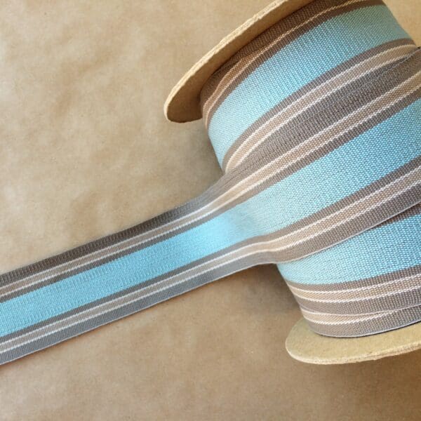 A spool of Eden 2 1/4 blue and grey striped ribbon.