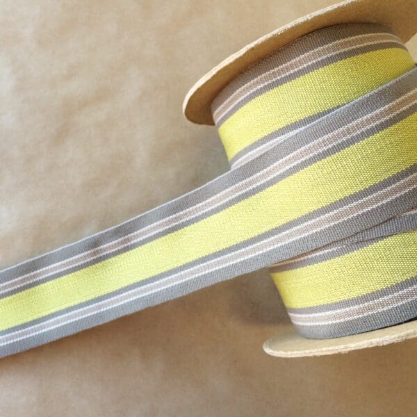 A yellow and grey striped ribbon on top of an Eden 2 1/4 spool.