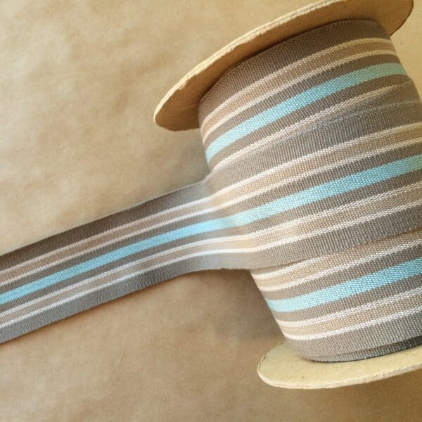 A spool of Eden 2 1/4 grey and blue striped ribbon.