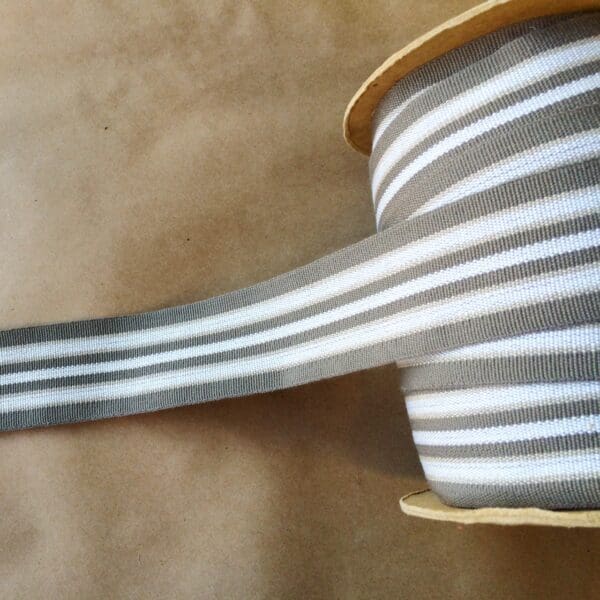 A grey and white striped Eden 1.5 and 2IN Tapes-Indoor and Outdoor ribbon on a table.