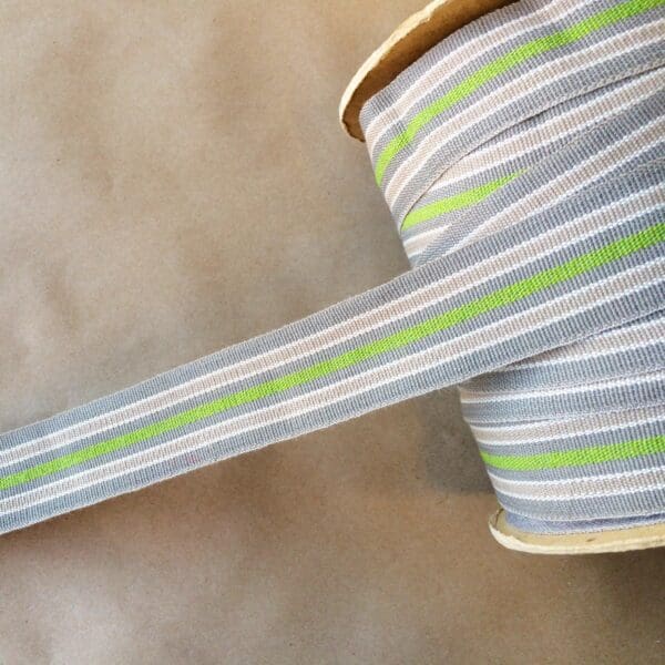 A gray and green striped Eden 1.5 and 2IN Tapes-Indoor and Outdoor ribbon on a table.