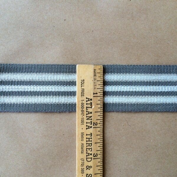 A gray and white striped Eden 1.5 and 2IN Tapes-Indoor and Outdoor ribbon on a piece of paper.