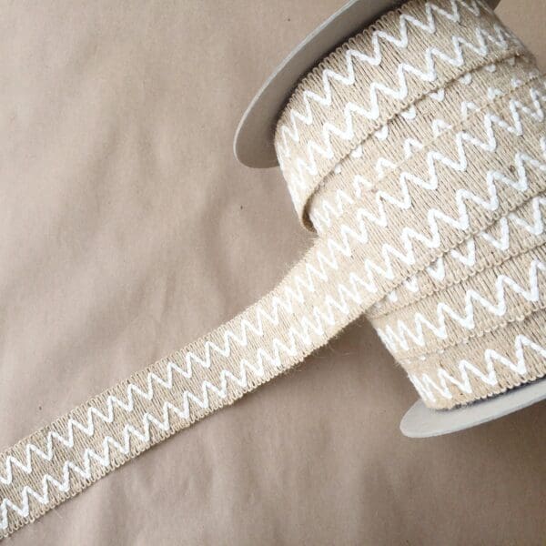 A spool of Essex 2IN white and beige chevron ribbon.