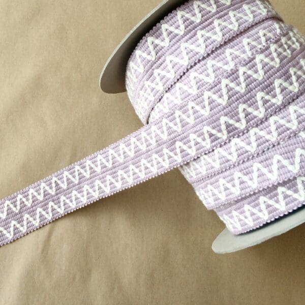 A spool of Essex 2IN purple and white zig zag ribbon.