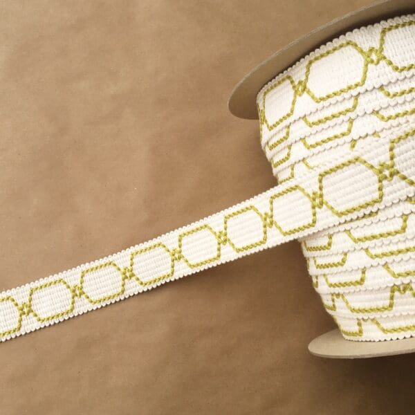 A yellow and white striped Genesis 1.5 IN ribbon on a brown background.