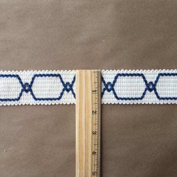 A blue and white woven Genesis 1.5 IN belt with a ruler.