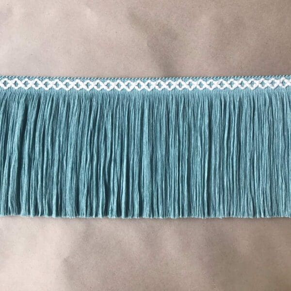 A teal fringe trim on a table.