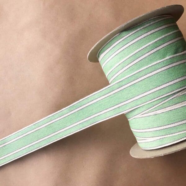 A green and white striped Balcony Outdoor Tapes on a spool.