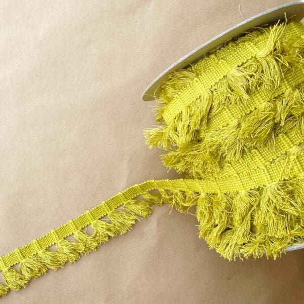 A yellow Gypsy Fringe 2IN ribbon with fringes on it.