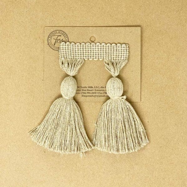 A pair of 5IN Chunky Tassel Fringe on a brown background.