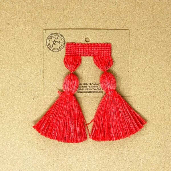 A pair of 5IN Chunky Tassel Fringe earrings on a brown background.