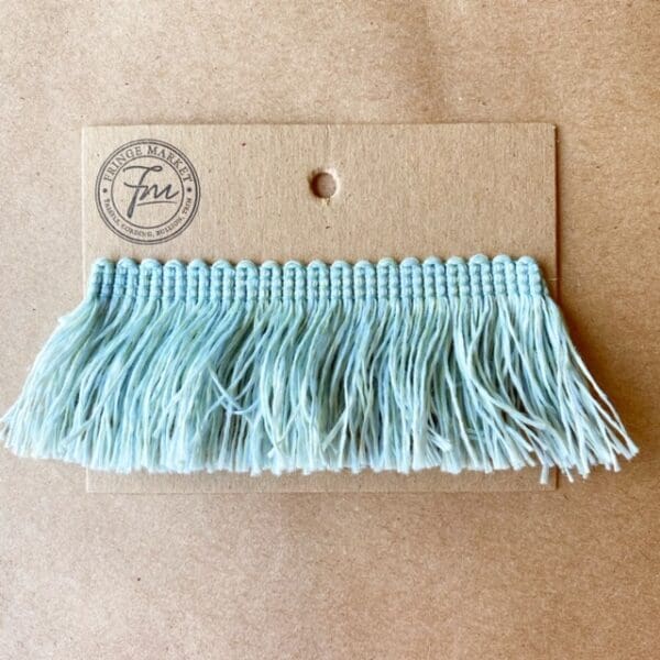 A light blue Outdoor 2IN Cut Brush Fringe with a tag on it.
