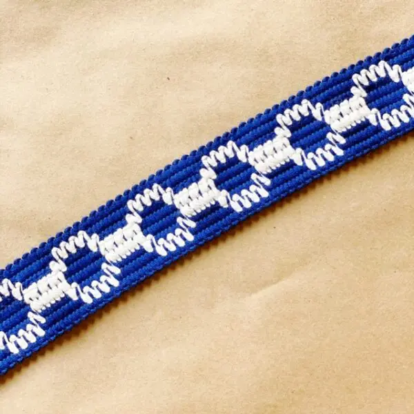 A blue and white Soho 1.5 Outdoor Tapes braided ribbon on a table.
