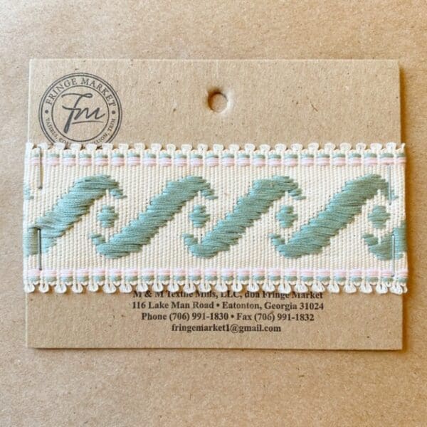 A blue and white Surf's Up 1 3/4 IN Tape embroidered ribbon on a card.