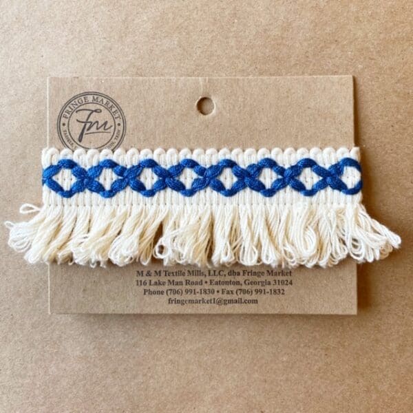 A blue and white Loopy Fringe 1.5 IN on a card.