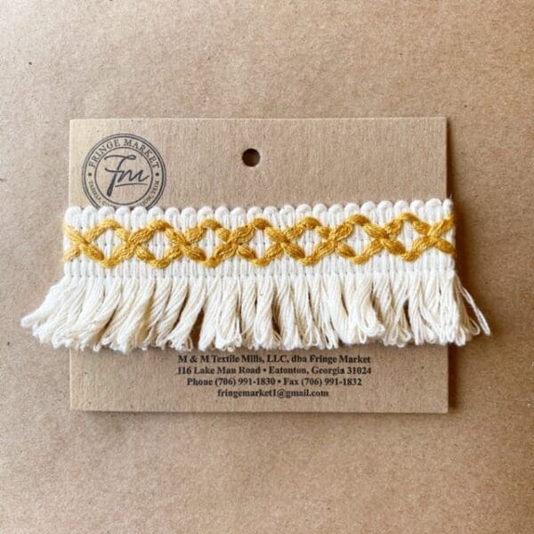 A Loopy Fringe 1.5 IN braided tassel on a piece of paper.