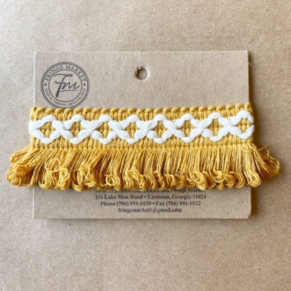 A Loopy Fringe 1.5 IN embroidered tassel on a card.