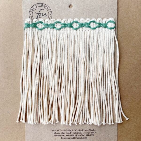 A white and green Chainette Skirt Fringe 8IN on a piece of paper.