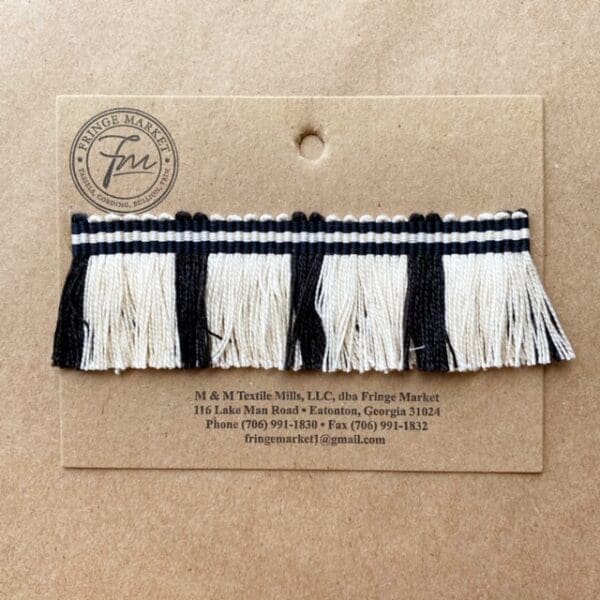 A black and white Circus Fringe 1.25IN trim on a piece of paper.