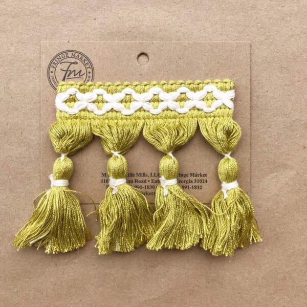 Frills Tassel Fringe 3.5 IN in yellow and white on a piece of paper.