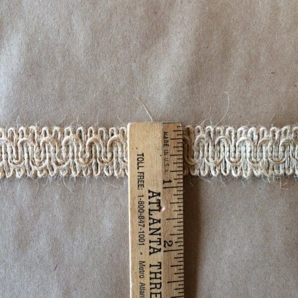 A ruler next to a piece of paper with a Jute Scroll Gimp trim.