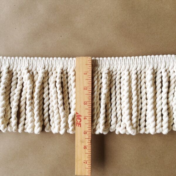 A measuring tape with Natural Cotton Buillions 2-12 INCHES on it.