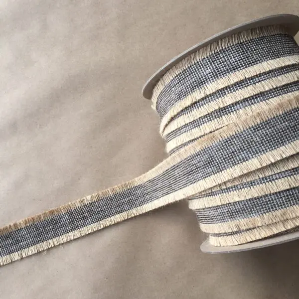 A spool of Navajo Jute Tapes 2IN ribbon on a table.
