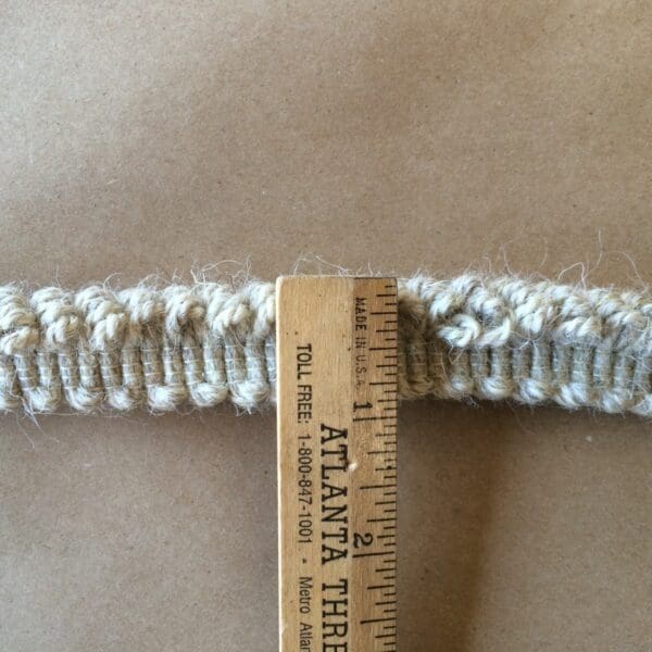 Nubby Fringe Wool - Natural is placed next to a crocheted piece of fabric.