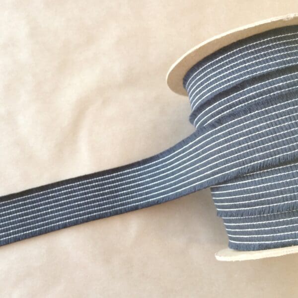 A spool of Organix Tapes blue and white striped ribbon.