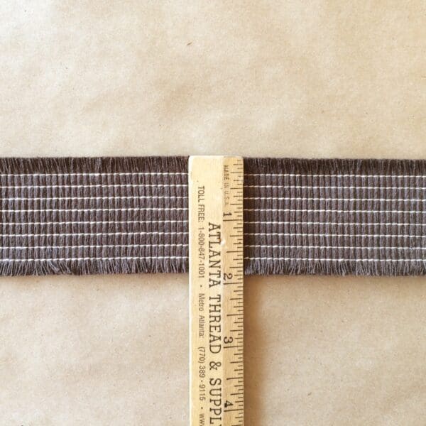 An Organix Tapes is used to measure the length of a strip of fabric.