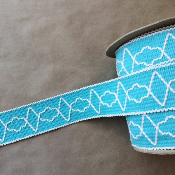A roll of Quincy Tapes blue and white embroidered ribbon.