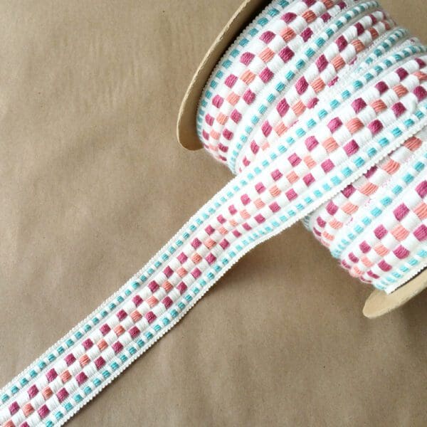 A roll of Rio Braids with a pink and blue checkered pattern.