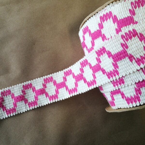 A pink and white woven ribbon on a Soho 2 1/4.