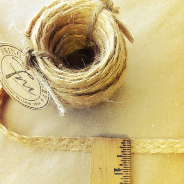 A piece of Jute Gimp with a measuring tape next to it.
