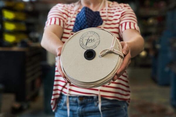A woman in a red and white striped shirt is holding a American Heroes Tape – 3/8 IN.