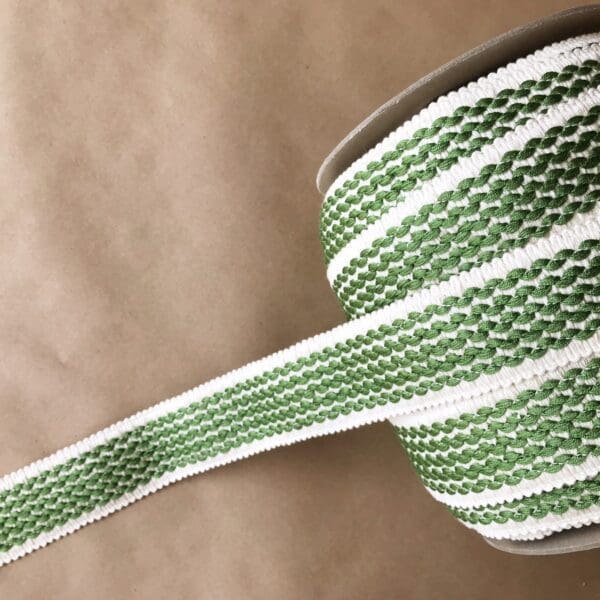 A green and white striped Barnsley 2IN Tapes ribbon on a table.