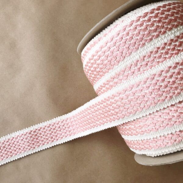 A pink and white striped Barnsley 2IN Tapes ribbon on a brown background.