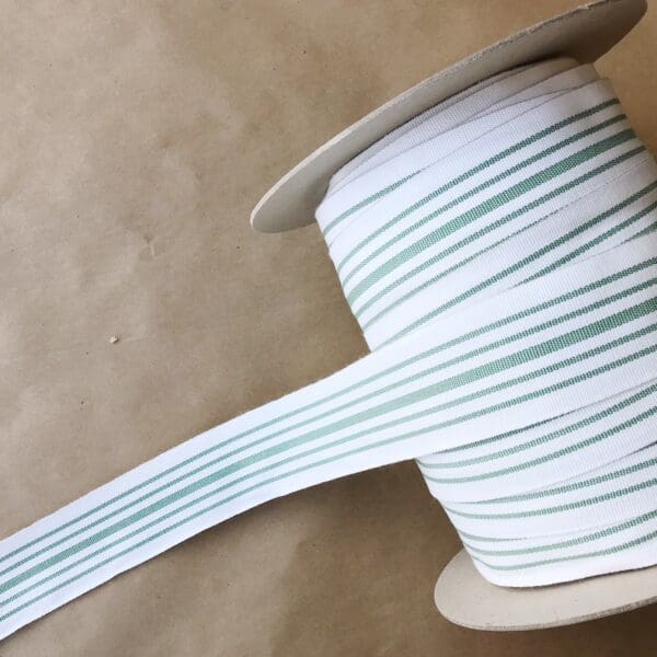 A green and white striped Eden 1.5 and 2IN Tapes-Indoor and Outdoor ribbon on a table.