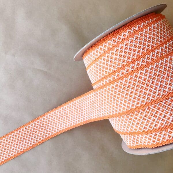 A spool of Camlett 2IN Outdoor Tapes orange and white polka dot ribbon.