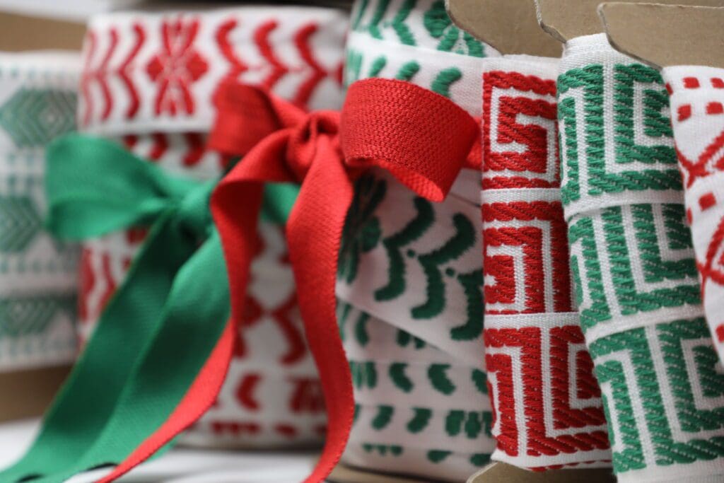 Christmas ribbons in boxes with red and green ribbons.