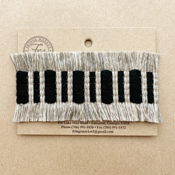 A Fresco Outdoor Fringed Tapes with black and white stripes on it.