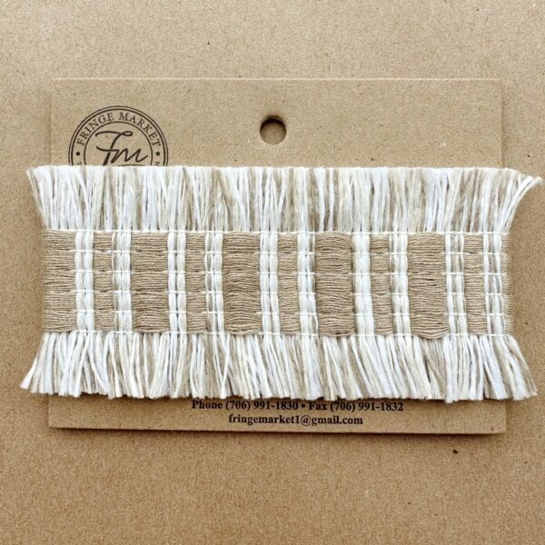 A white and beige Fresco Outdoor Fringed Tapes on a brown card.