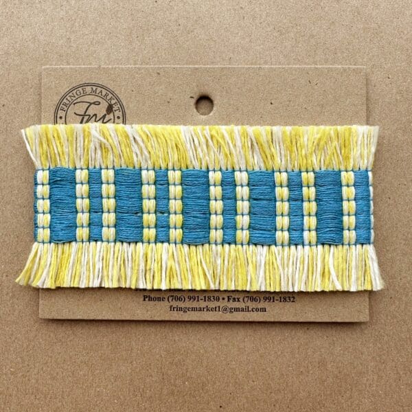 A blue and yellow Fresco Outdoor Fringed Tapes ribbon on a piece of cardboard.