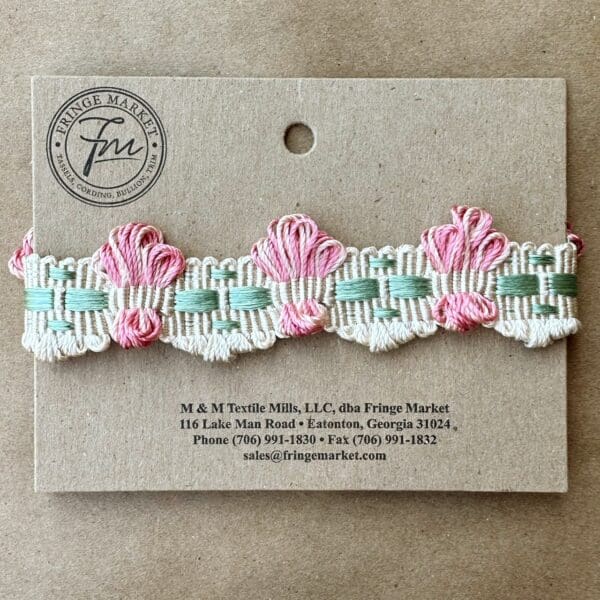 A pink and white embroidered Brooklyn Braids on a card.